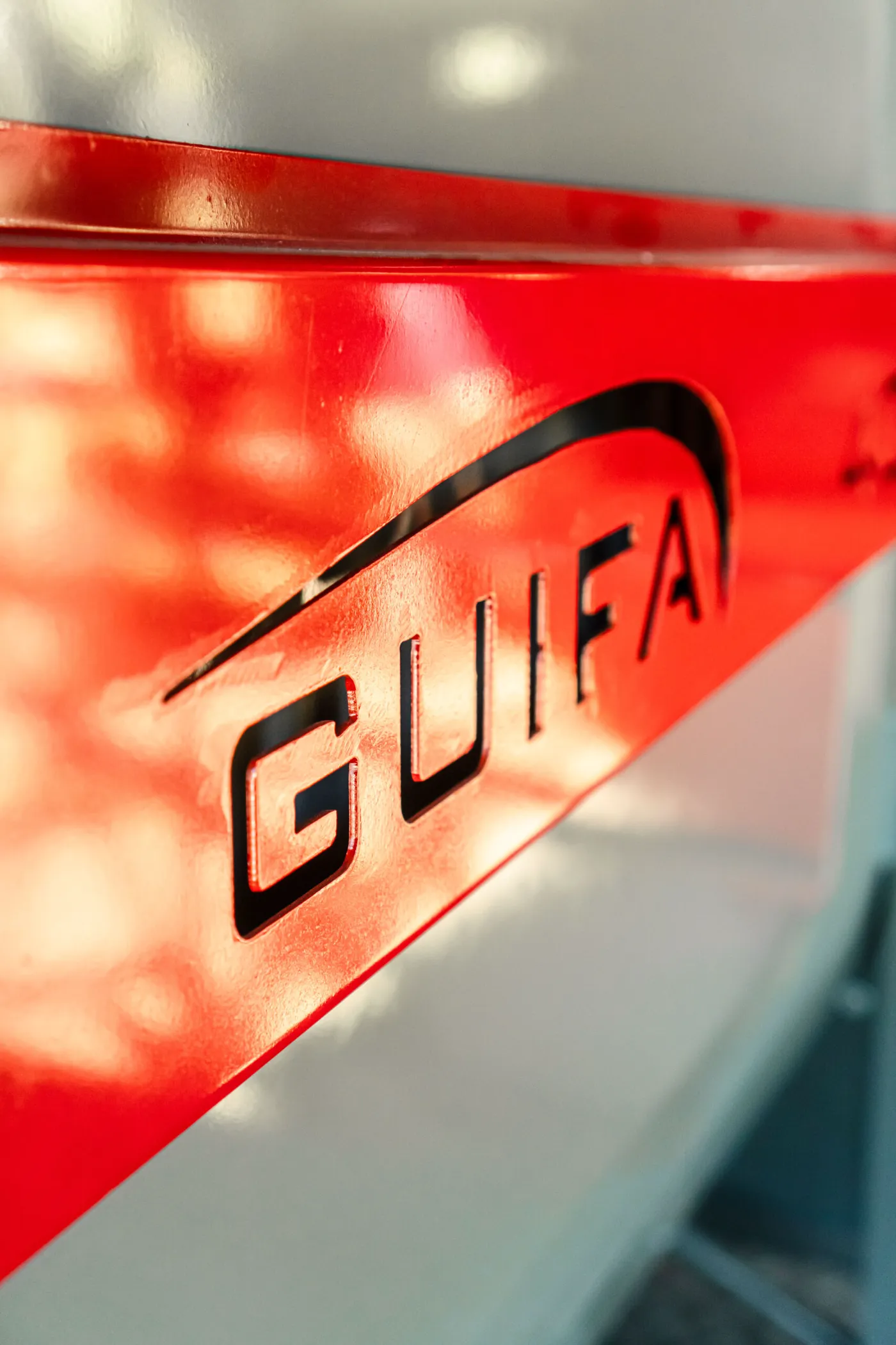 Chapa roja plegada con el logo de Guifa calado, detalle de terminación de un equipo