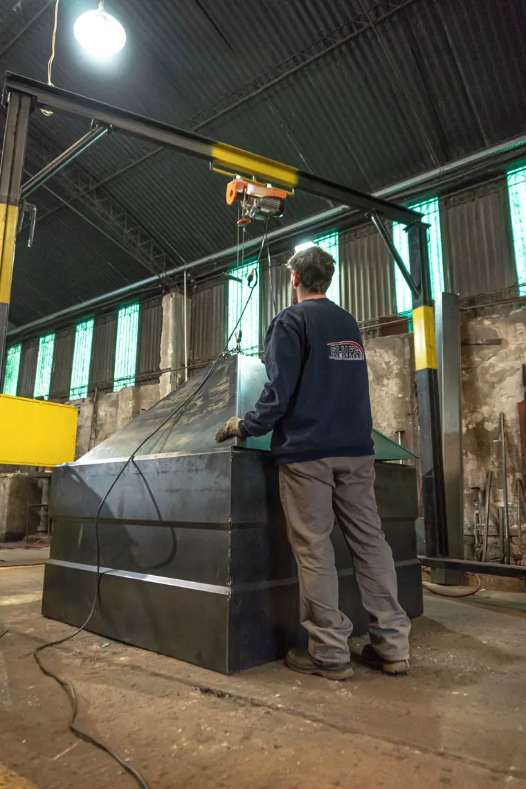 Operario junto a un cuerpo de tolva en la nave de la planta